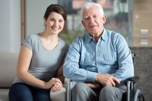 A woman and an older man sitting in chairs.